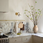 Marie Petite Sconce shown in Heirloom Brass. Interior Design by Design Assembly