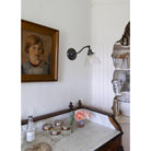 Grace Sconce shown in Graphite Patina with a  Clear Glass shade and Filament Bulb. Interior design by Sarah J. Meyer Design