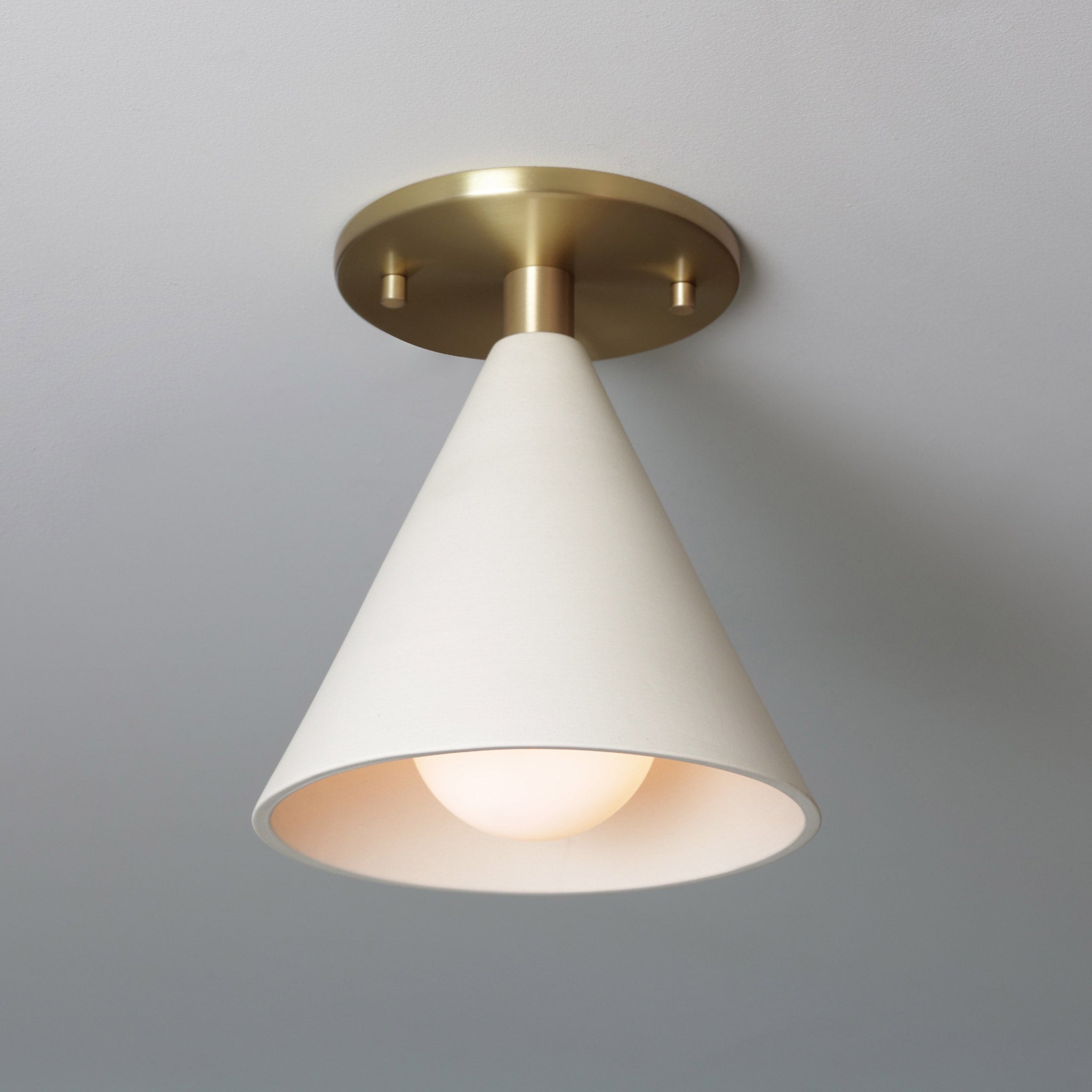 Petra Ceramic Surface shown in Heirloom Brass with a Tala Sphere II Bulb