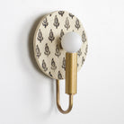 Edith ADA Sconce shown in Heirloom Brass with Black and Cream Floral Ceramic